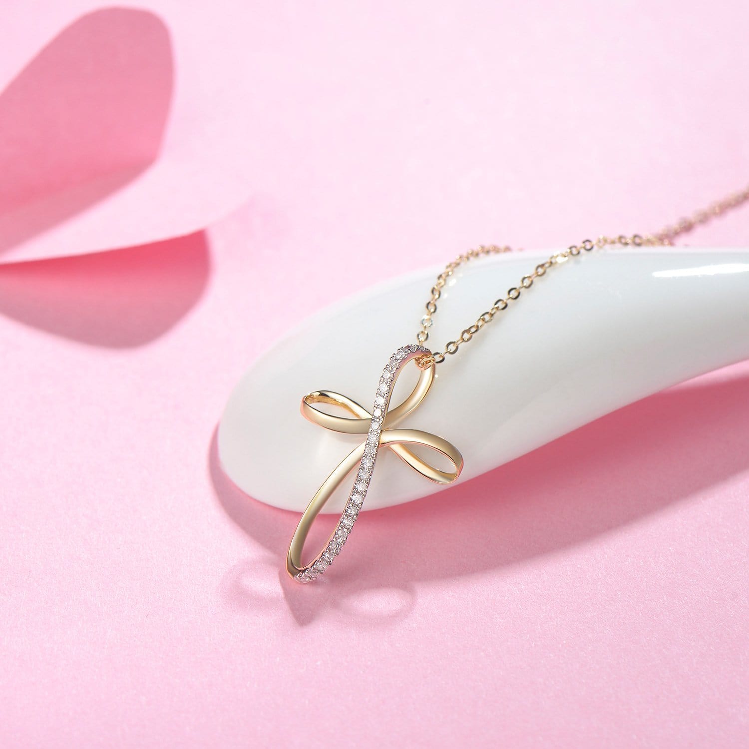 Delicate dainty gold necklace with ribbon inspired cross design